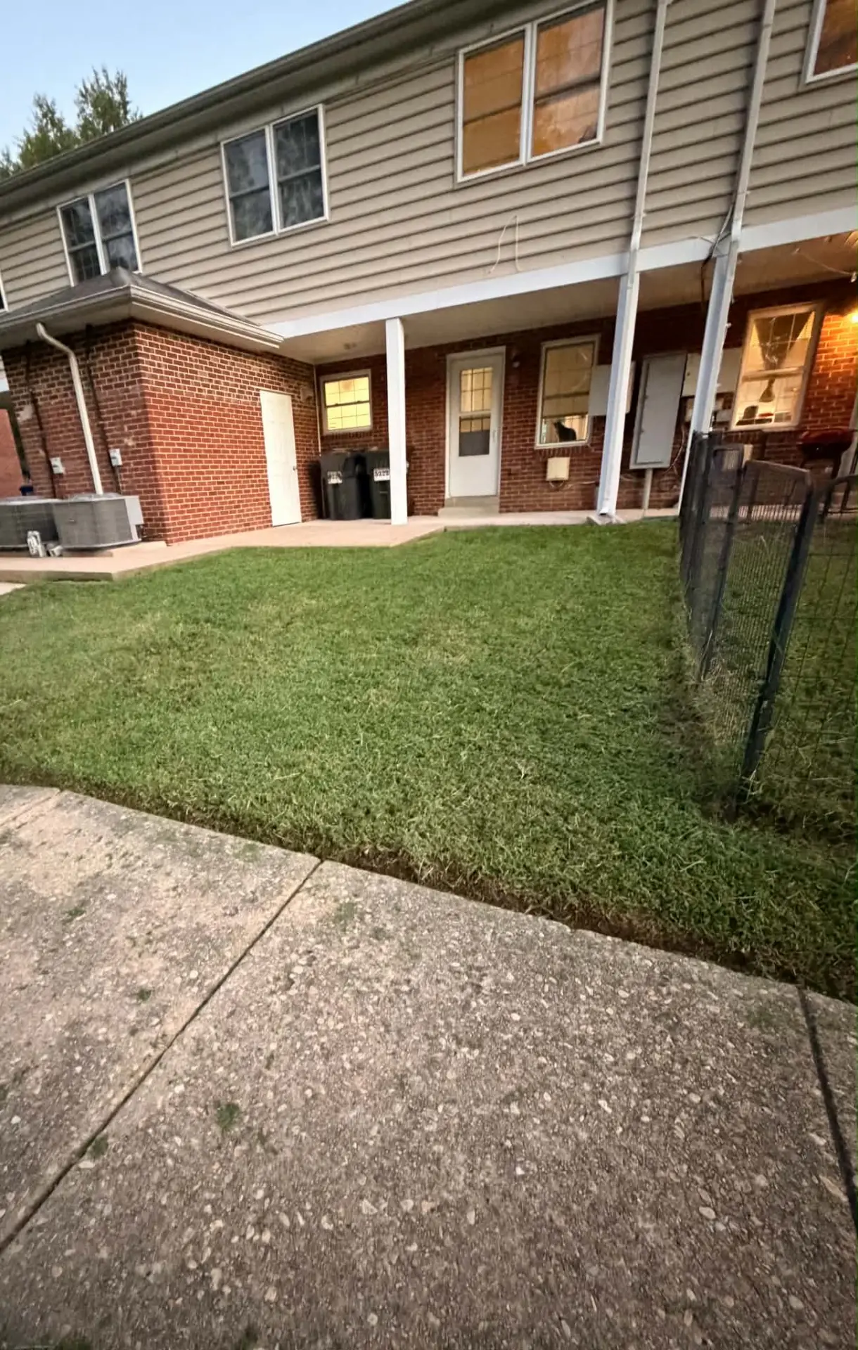 Example qualifying townhome backyard with a freshly cut lawn by a brick home